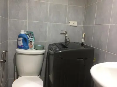 a bathroom with a white toilet and a sink at Arcilla stay cation in Manila