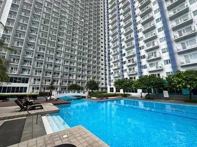 a large apartment building with a large swimming pool at Aeva's Cozy Stays in Manila
