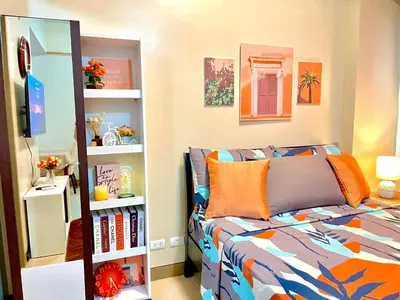 a bedroom with a bed and a book shelf at Airport NAIA T3 Condotel in Manila