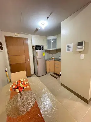 a kitchen with a table with a vase of flowers on it at Airport NAIA T3 Condotel in Manila