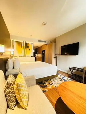 a hotel room with a bed and a table at MADR Excellence at Novotel Manila Hotel Residence Acqua in Manila