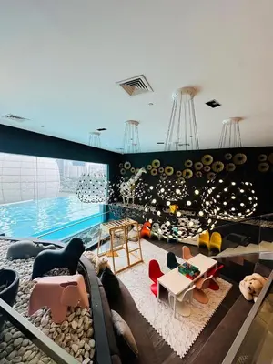 a room with a swimming pool and a room with furniture at MADR Excellence at Novotel Manila Hotel Residence Acqua in Manila