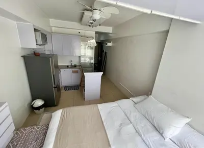 a bedroom with a white bed and a kitchen at Avida Towers Intima Paco, Manila Studio Unit in Manila