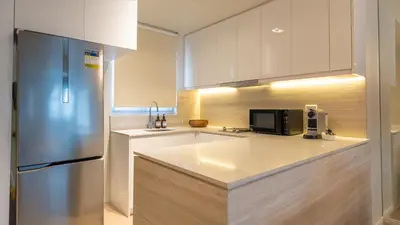 a kitchen with a refrigerator and a microwave at Cozy Flat at Makati s Coolest St in Manila