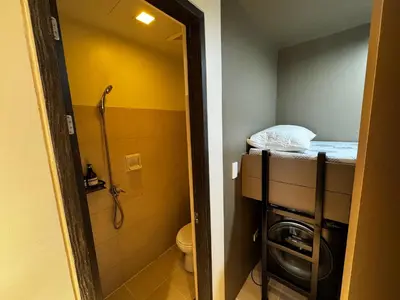 a small bathroom with a shower and a toilet at Cozy Flat at Makati s Coolest St in Manila
