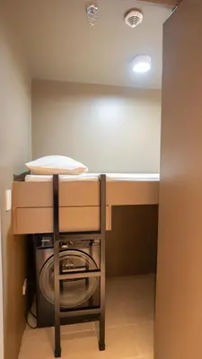 a laundry room with a washing machine under a counter at Cozy Flat at Makati s Coolest St in Manila