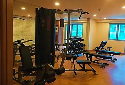 a gym with several tread machines in a room at Cozy Flat at Makati s Coolest St in Manila