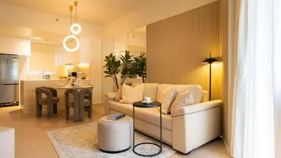 a living room with a white couch and a kitchen at Cozy Flat at Makati s Coolest St in Manila