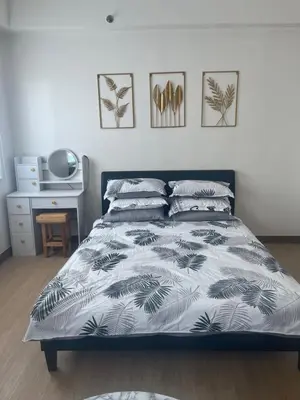 a bedroom with a bed with a black and white comforter at Aras Solace Place in Trece Martires