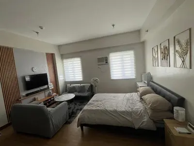 a bedroom with a bed and a couch and a tv at Aras Solace Place in Trece Martires