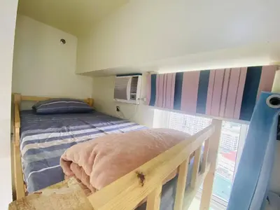 a bedroom with a bunk bed and a window at timoncondotel city view in Manila
