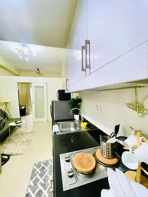 a kitchen with a stove top oven next to a sink at SMDC Shore Residences in Manila