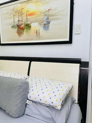 a painting of boats on the wall above a bed at SMDC Shore Residences in Manila