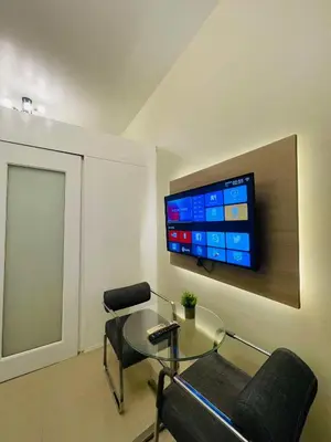 a living room with a table and a tv on the wall at SMDC Shore Residences in Manila