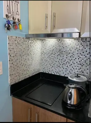 a kitchen counter top with a tea pot on a stove at One Palm Tree Villas Near NAIA 3 in Manila