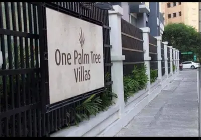 a one palm tree villas sign on a fence at One Palm Tree Villas Near NAIA 3 in Manila