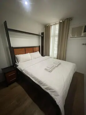 a bedroom with a bed with two towels on it at The Serenity Tower 2610 in Manila