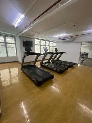 a row of treadmills in a gym with wooden floors at The Serenity Tower 2610 in Manila