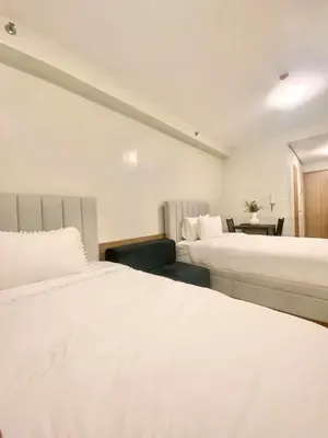 a hotel room with two beds and a desk at Bella Notte Staycation - SMDC Shore 2 MOA Complex in Manila