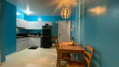 a kitchen with a table and a blue wall at The Radiance Manila Bay by Mary in Manila