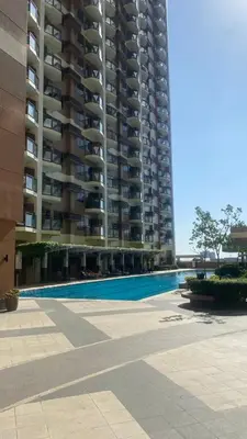 a swimming pool in front of a large apartment building at The Radiance Manila Bay by Mary in Manila