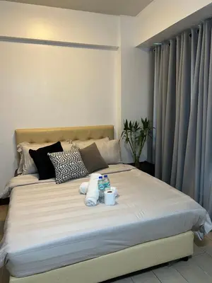 a bed with two towels and two cups on it at Two Palm Tree Villas by Trisha in Manila