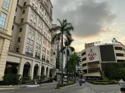 a city street with tall buildings and palm trees at Two Palm Tree Villas by Trisha in Manila