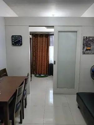 a living room with a table and a door at Bj's Staycation Manila - SEA Residences SM MOA in Manila