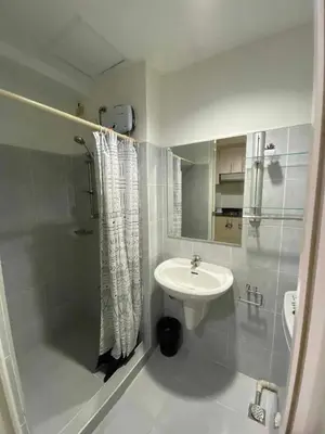 a white bathroom with a sink and a shower at Bj's Staycation Manila - SEA Residences SM MOA in Manila