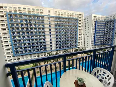 a balcony with a table and a view of a building at Bj's Staycation Manila - SEA Residences SM MOA in Manila