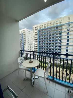 a balcony with a table and chairs and a view of a building at Bj's Staycation Manila - SEA Residences SM MOA in Manila