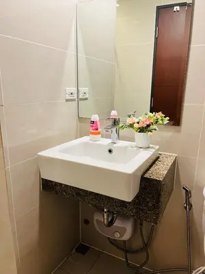 a bathroom with a white sink and a mirror at BGC One Uptown Residences in Manila