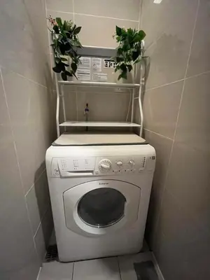 a washing machine with two plants on top of it at BGC One Uptown Residences in Manila