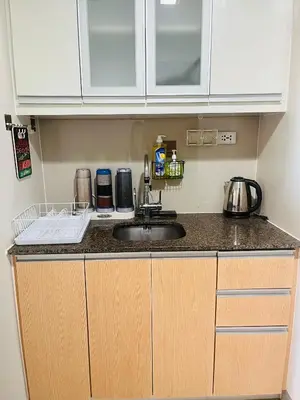 a kitchen with a sink and a counter top at BGC One Uptown Residences in Manila