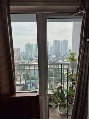 a view of a city from a balcony at Breeze Residences, Pasay City in Manila