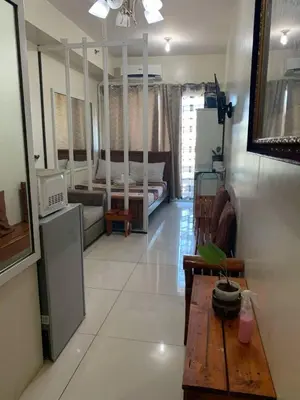 a living room with a couch and a table in a room at Breeze Residences, Pasay City in Manila
