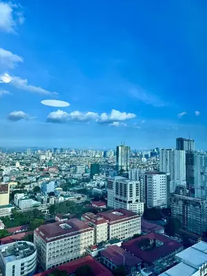 a view of a city with buildings and a frisbee in the sky at Cozy 1BR Condo in Manila Near US Embassy and Robinsons Place Manila in Manila