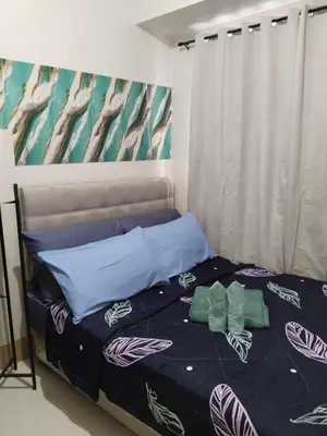 a bed with blue sheets and pillows in a bedroom at The Chill Spot Residences Property Management in Manila