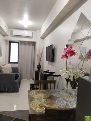 a living room with a table with flowers on it at The Chill Spot Residences Property Management in Manila