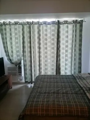a bedroom with curtains and a bed in a room at Premium 1Bedroom Condo Unit Near Airport, MOA, Casinos, SM Bicutan in Manila