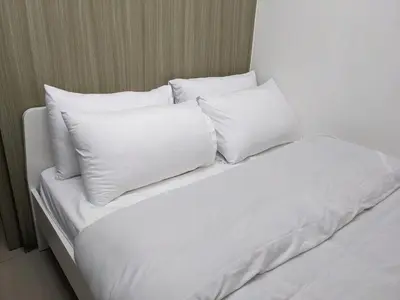 a white bed with four pillows on it at My Serenity Suite in Manila