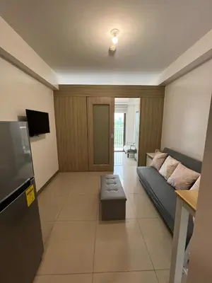 a living room with a couch and a tv at My Serenity Suite in Manila
