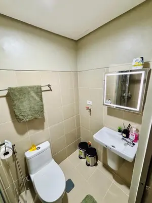 a bathroom with a toilet and a sink at Serenitude Staycation by Khaila - Fame Residences in Manila