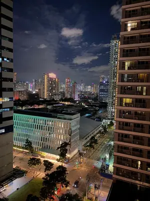 a view of a city at night with buildings at Serenitude Staycation by Khaila - Fame Residences in Manila