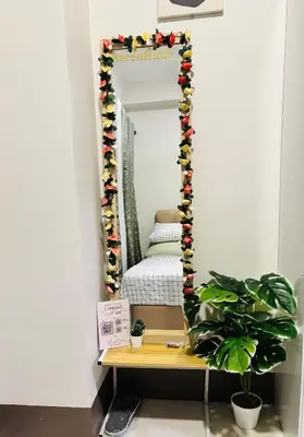 a mirror in a room with a table and a bed at Serenitude Staycation by Khaila - Fame Residences in Manila