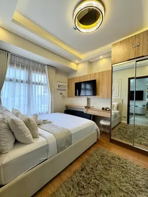 a large bedroom with a large bed and a desk at Manila Bay Suite in Manila
