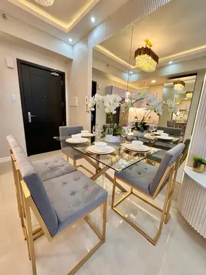 a dining room with a glass table and chairs at Manila Bay Suite in Manila
