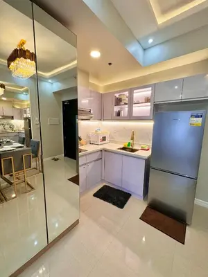 a kitchen with a refrigerator and a dining room at Manila Bay Suite in Manila
