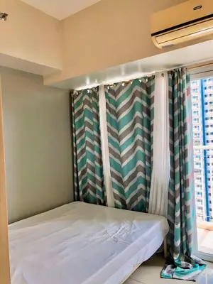 a small bed in a room with a window at Cosy Light Residences Unit Staycation in Manila