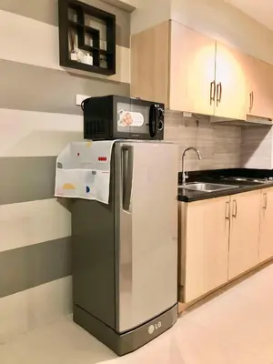a kitchen with a refrigerator and a sink at Cosy Light Residences Unit Staycation in Manila